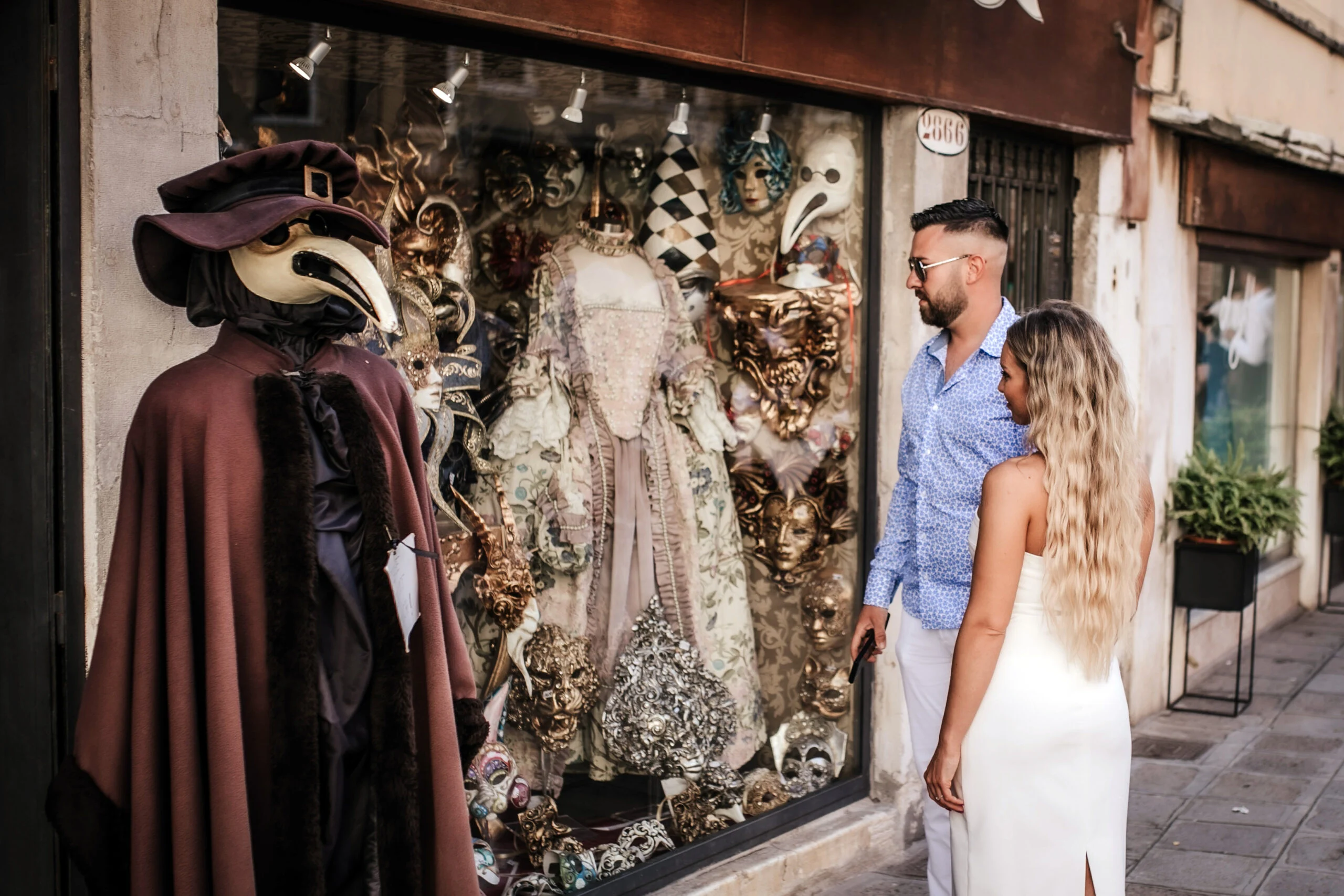 Couple looking into the window of a Venetian mask shop