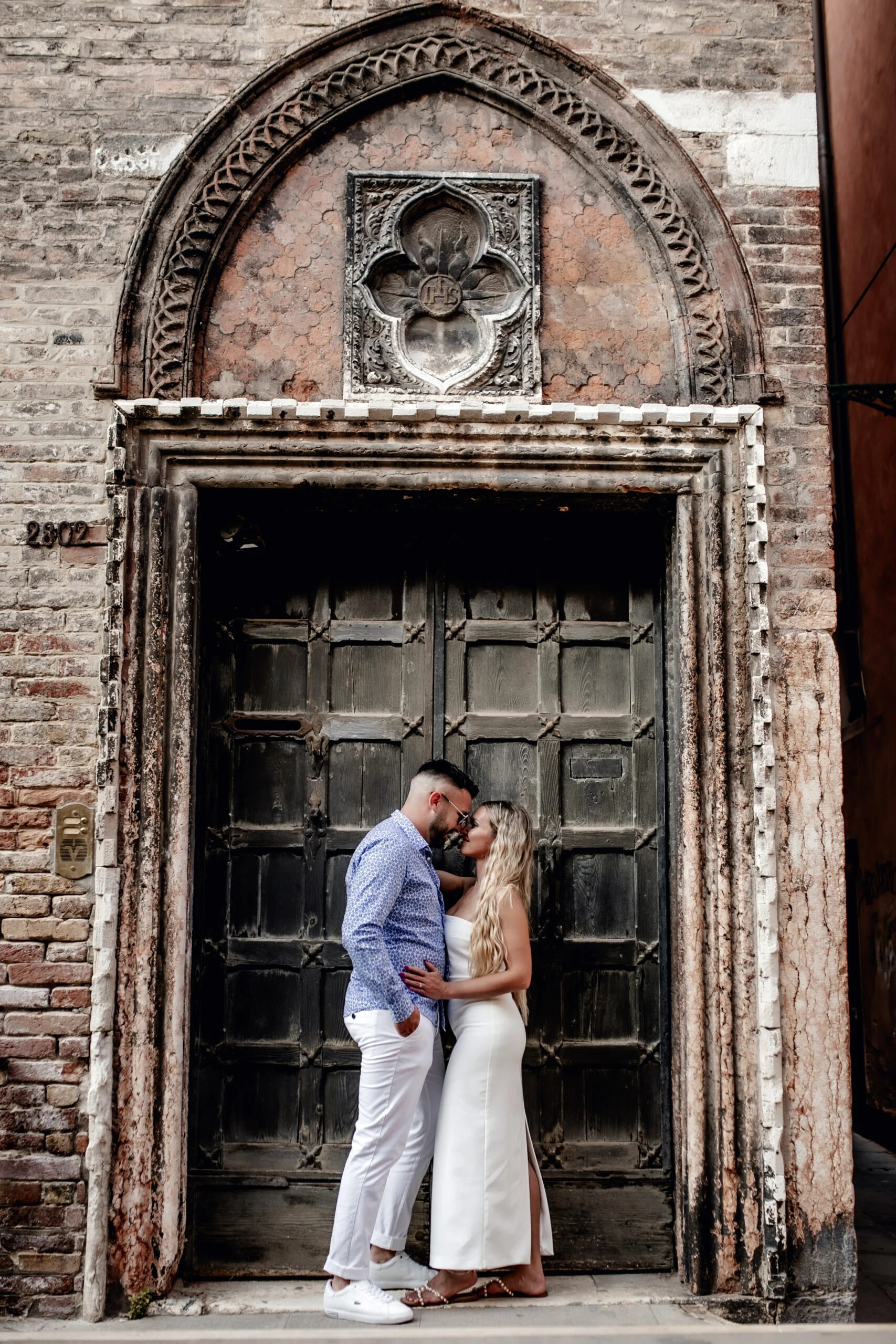 Couple embracing in an old carved stone doorway