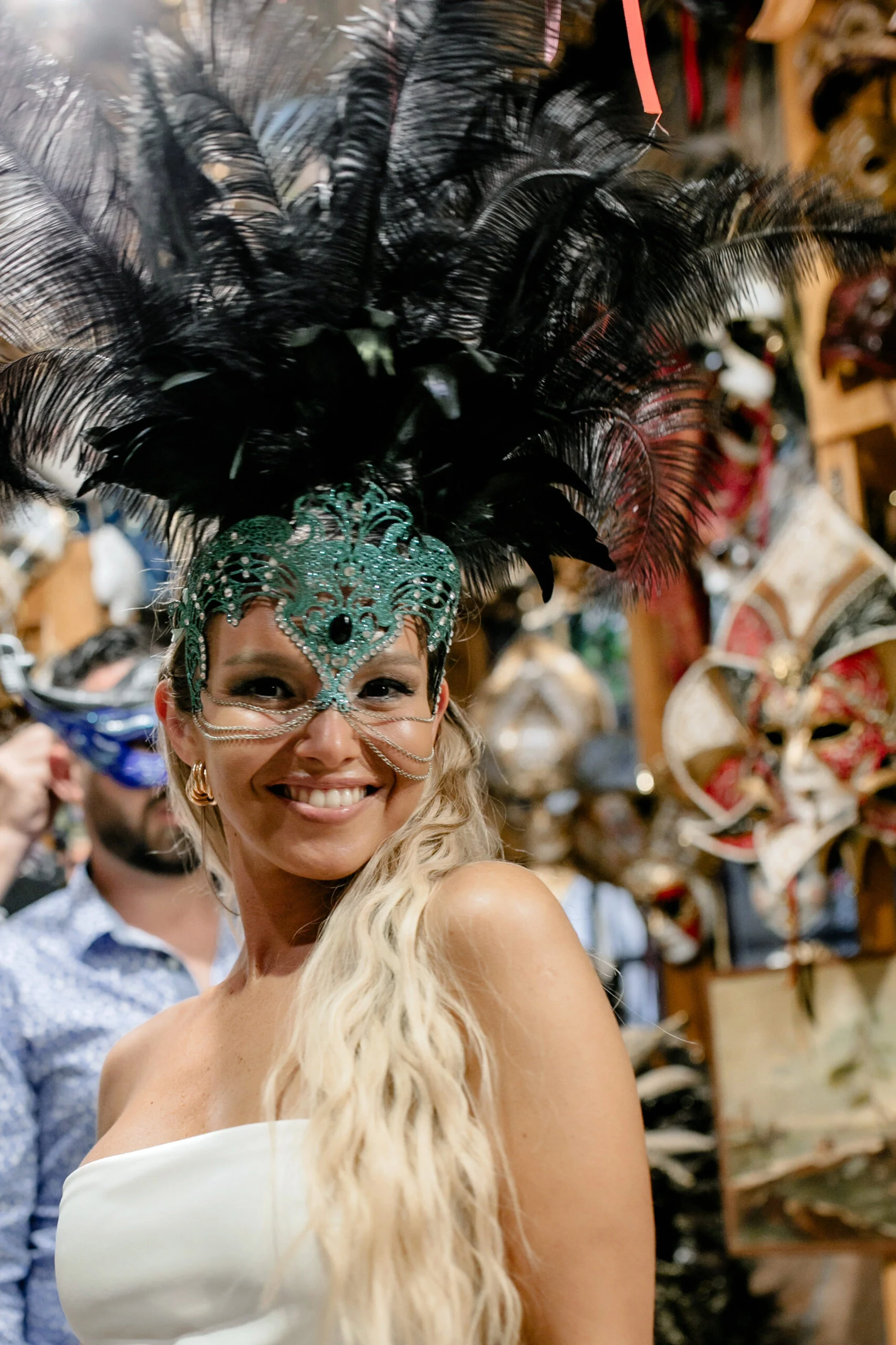 Woman wearing a green feathered carnival mask