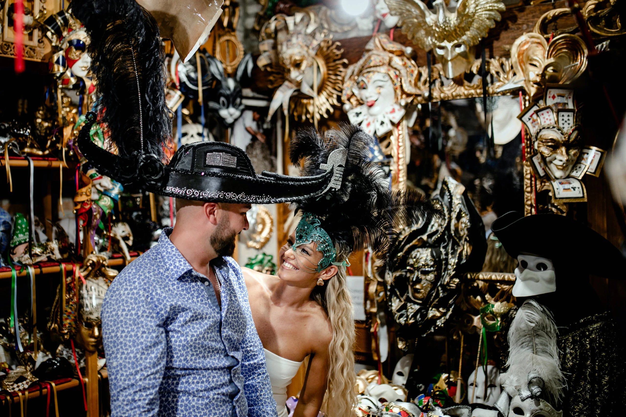 Couple trying on hats and masks outside a shop in Venice