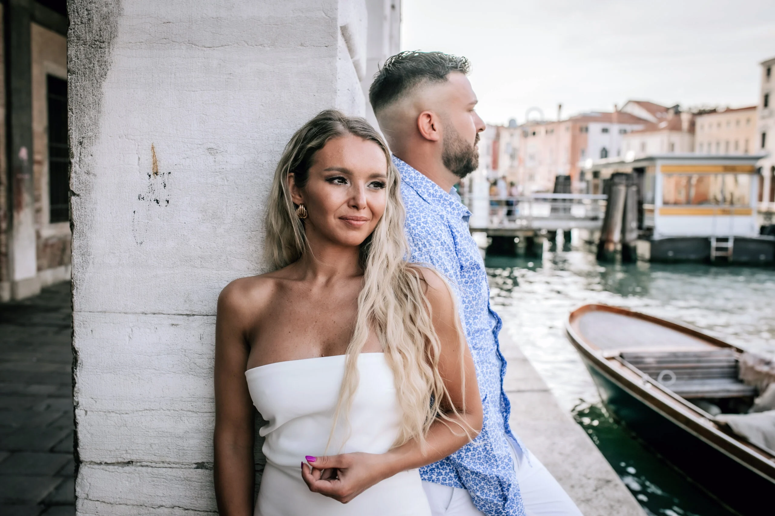 Couple resting against a wall by the water