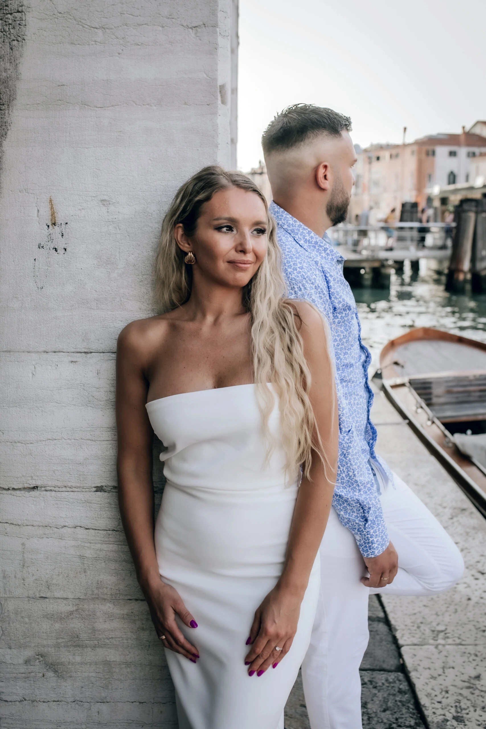 Woman leaning against a stone wall, the man behind her