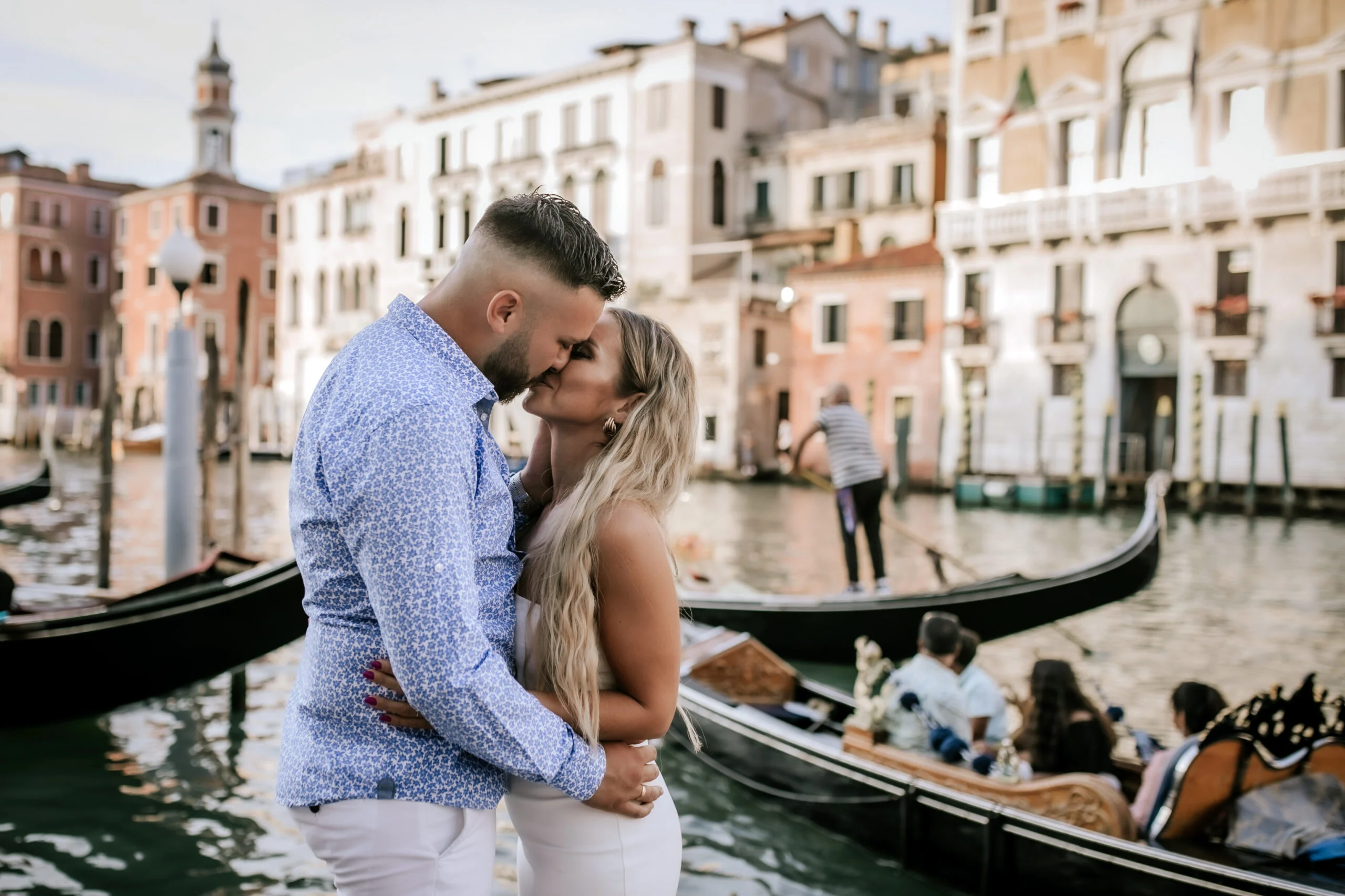 Couple by the water as a gondola passes