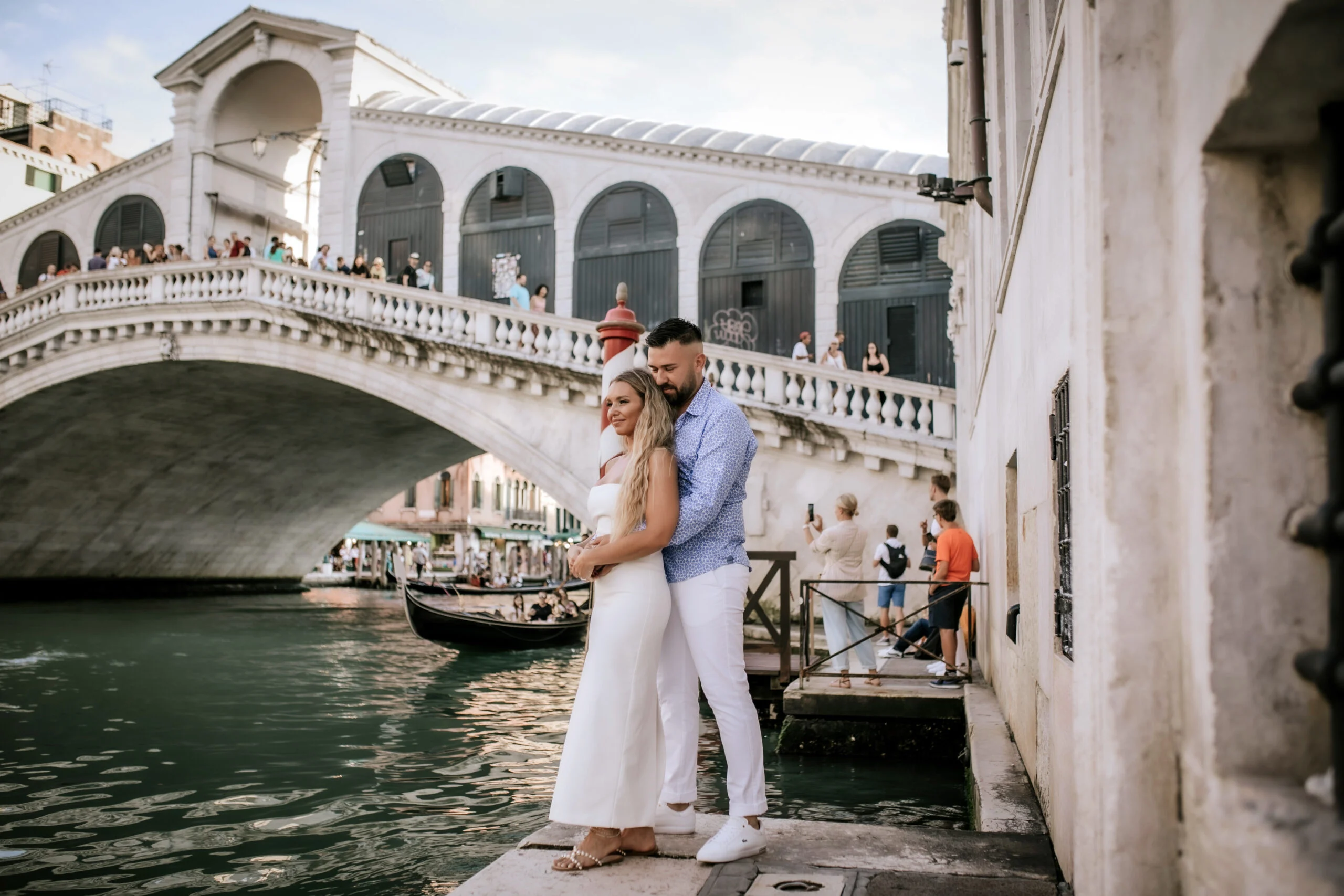 Couple standing together below the Rialto Bridge