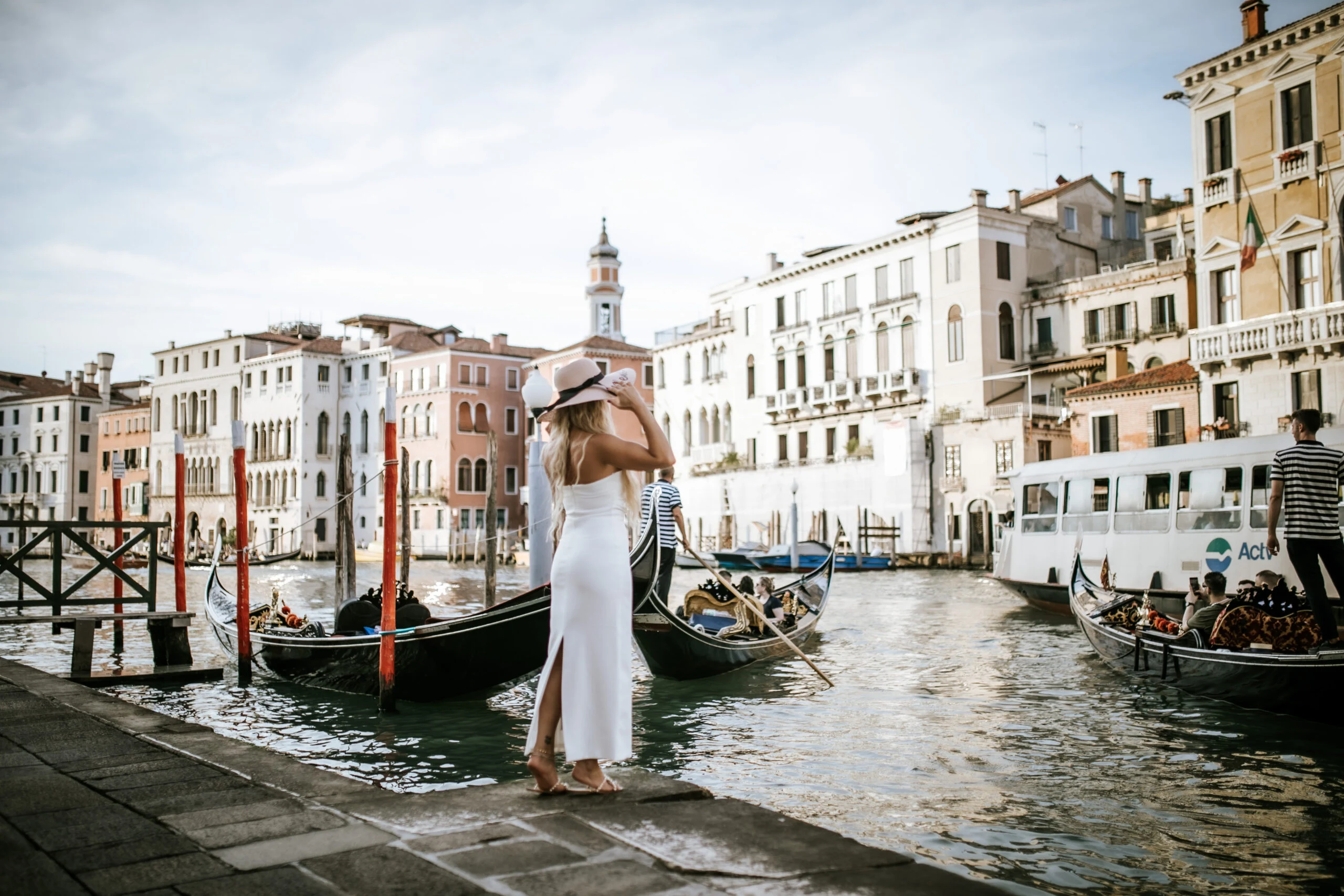 Woman walking along the quay beside the gondolas