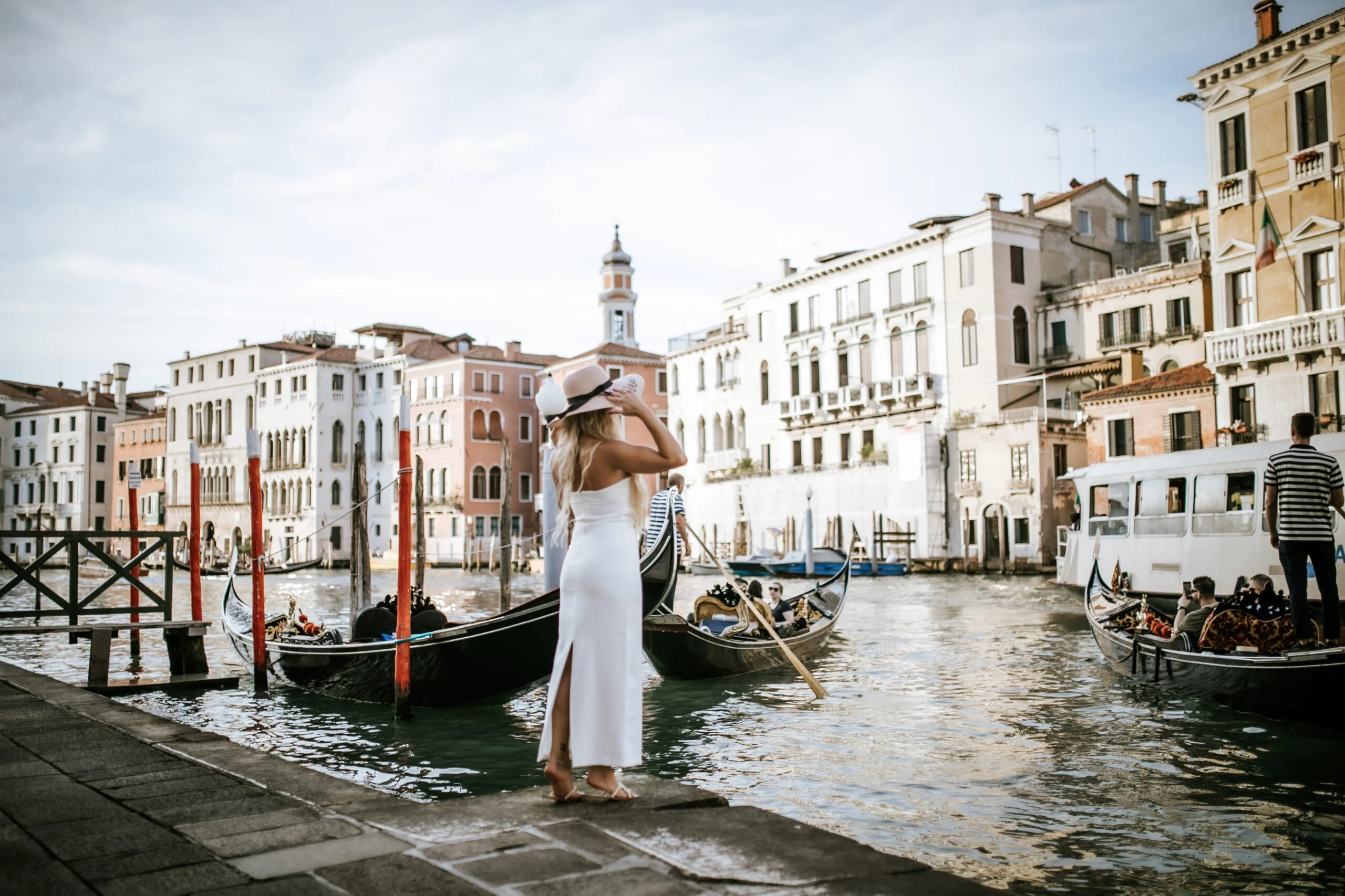Woman turning beside the gondolas on the Grand Canal