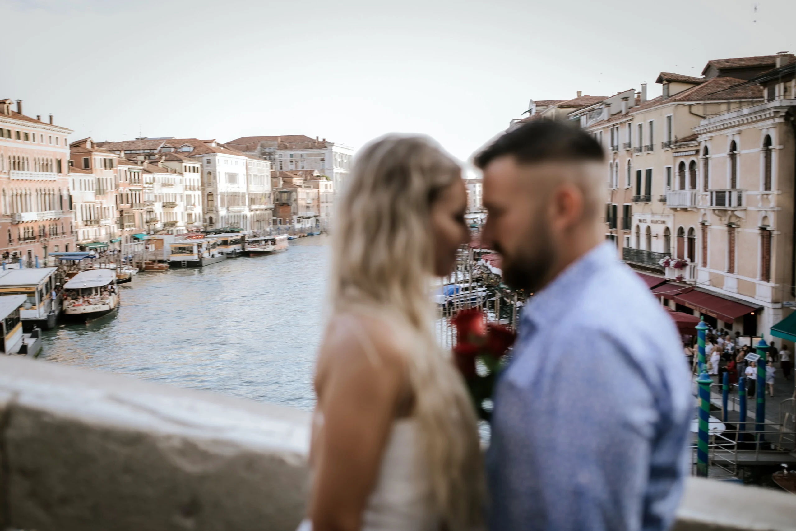 Couple standing close on the bridge, the canal behind them