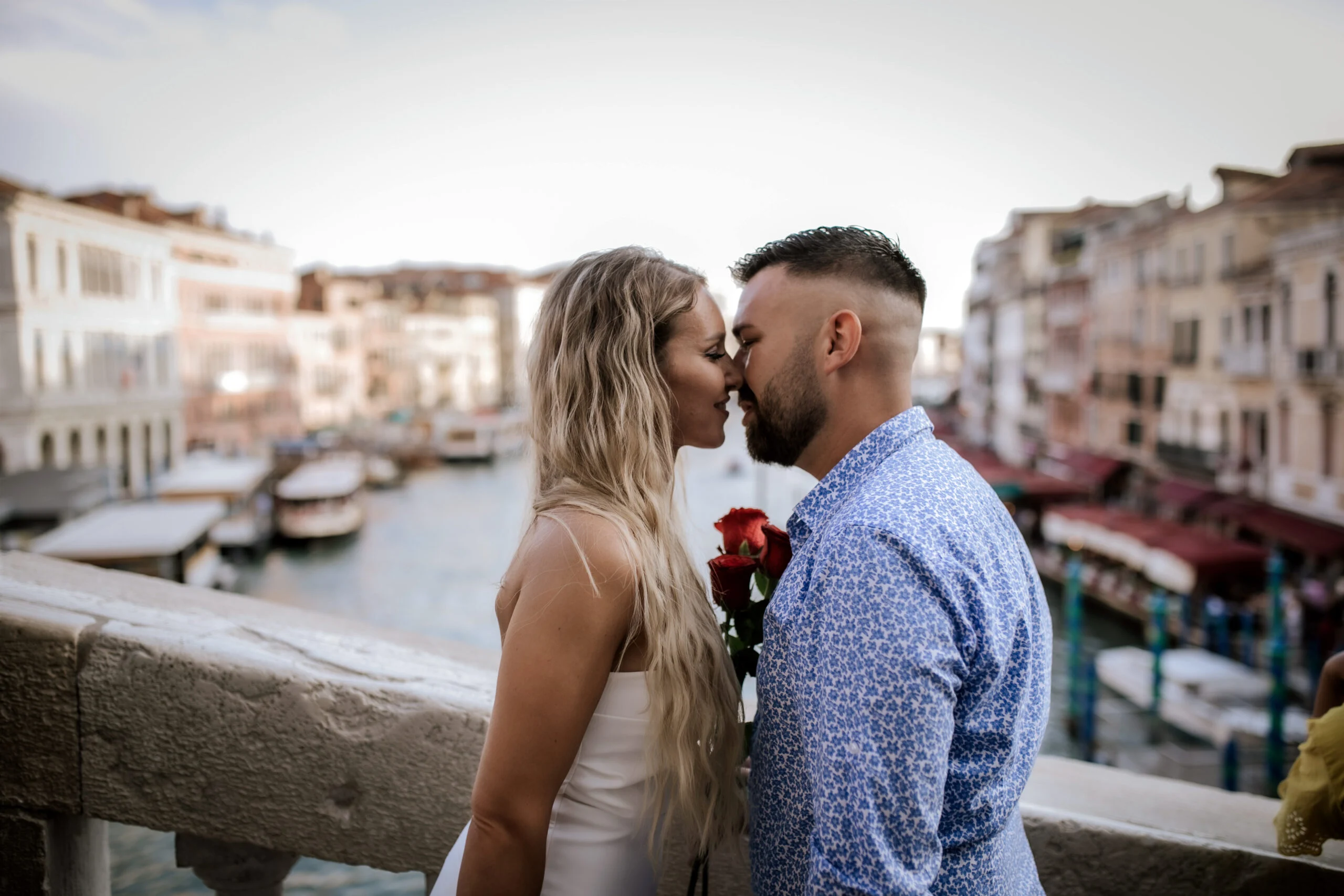 Couple about to kiss on a bridge above the Grand Canal