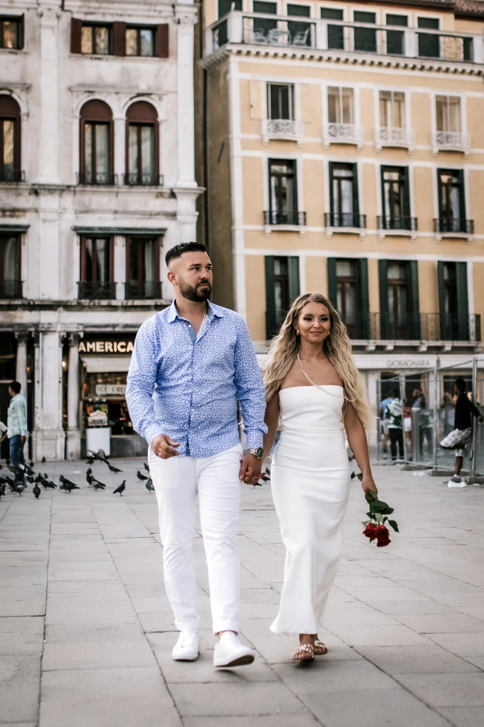 Couple walking through the square among the pigeons