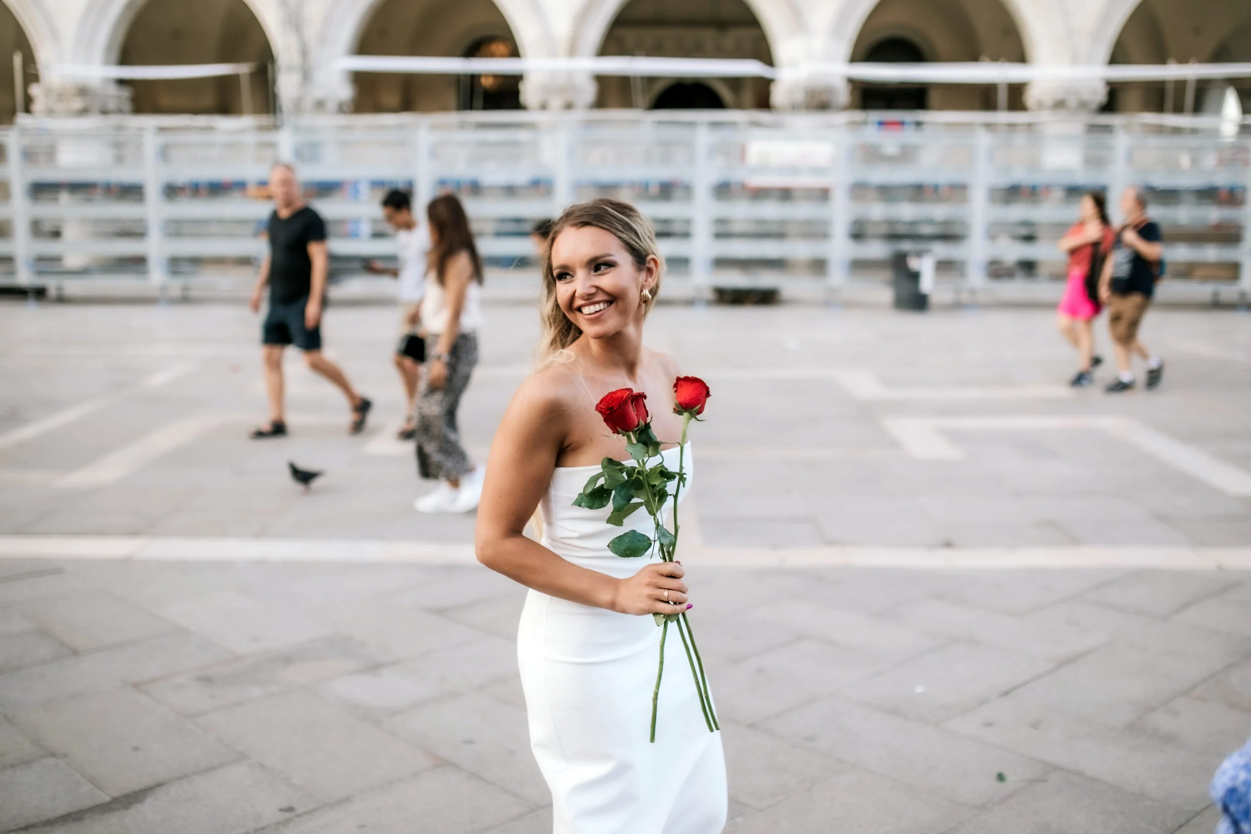 Woman holding red roses standing in the square