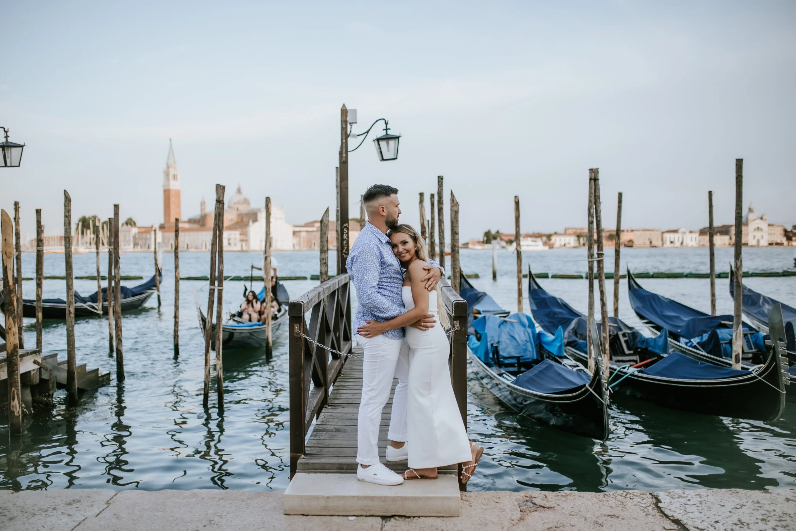 Couple standing on the pontoon between gondolas