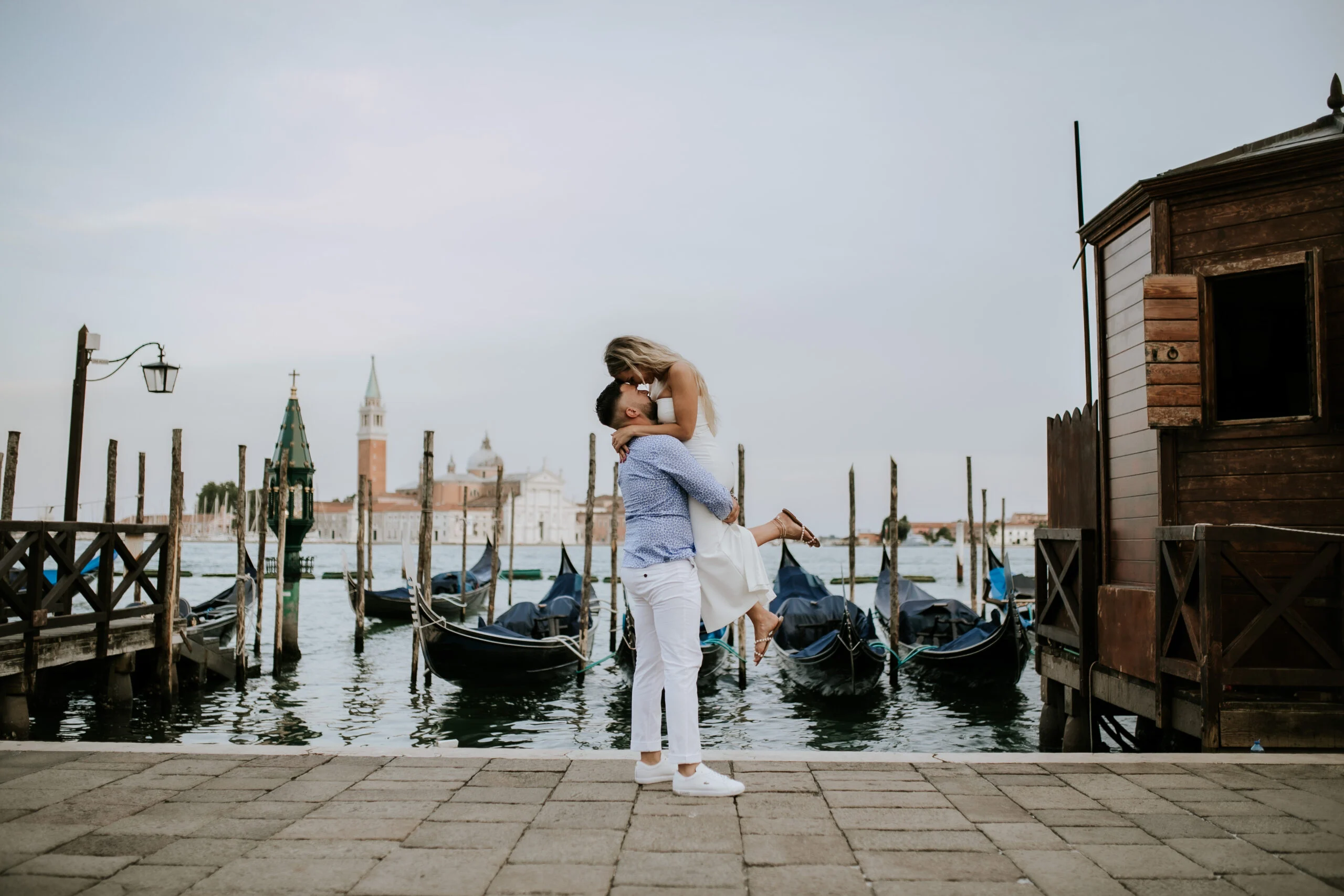 Couple embracing beside the moored gondolas