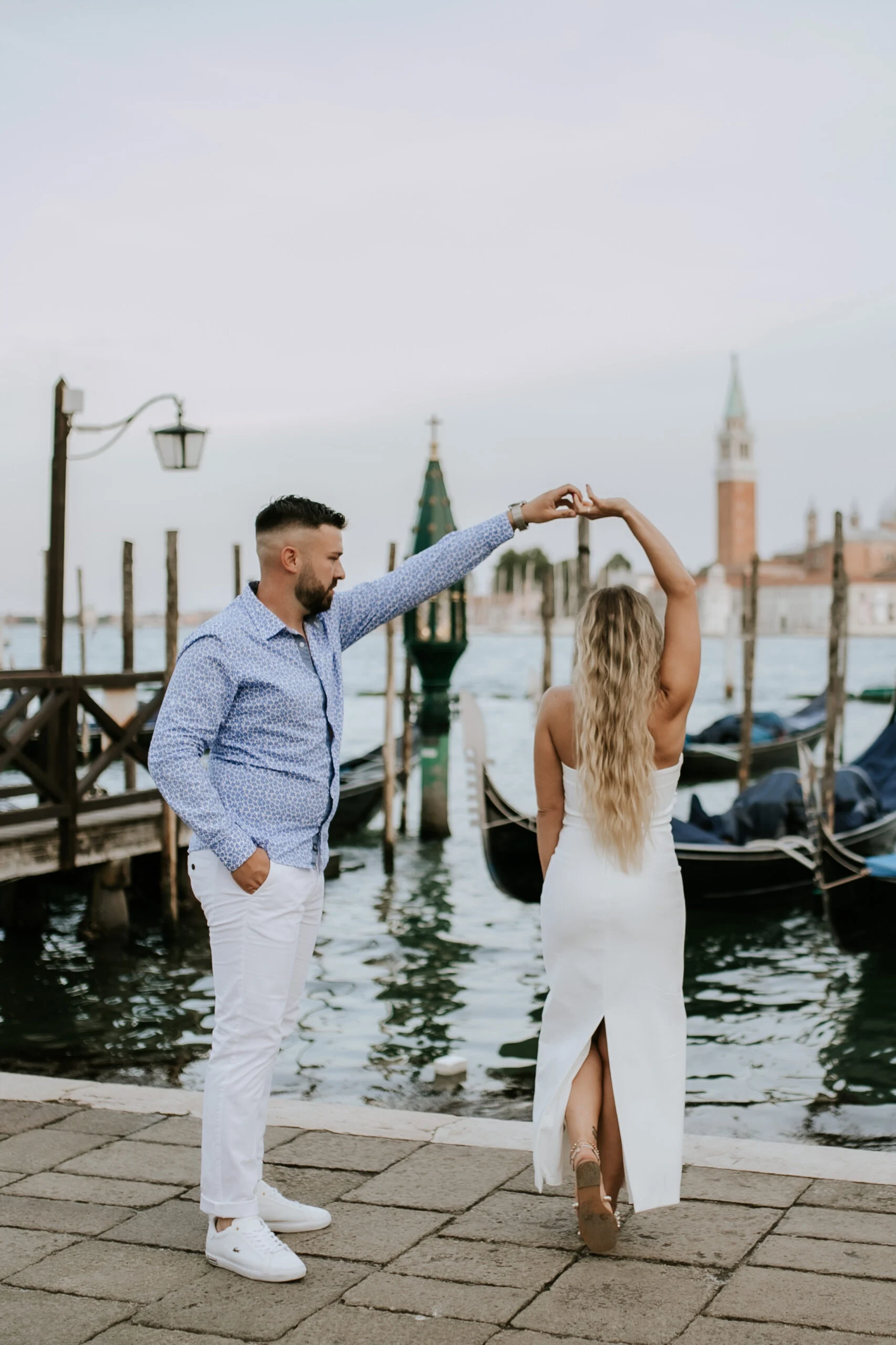 Couple dancing on the quay in front of the lagoon