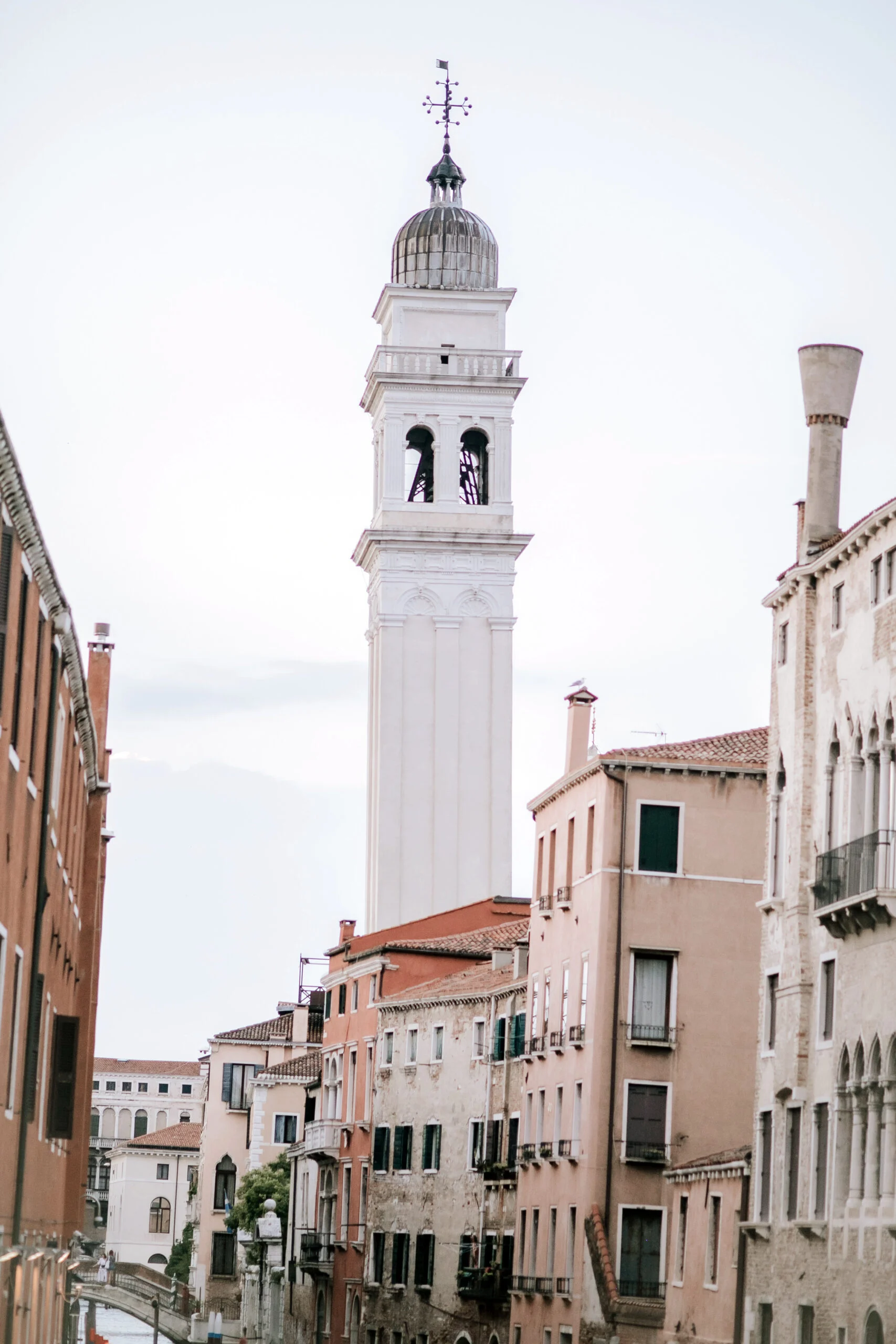 The leaning bell tower of a Venetian church above the rooftops