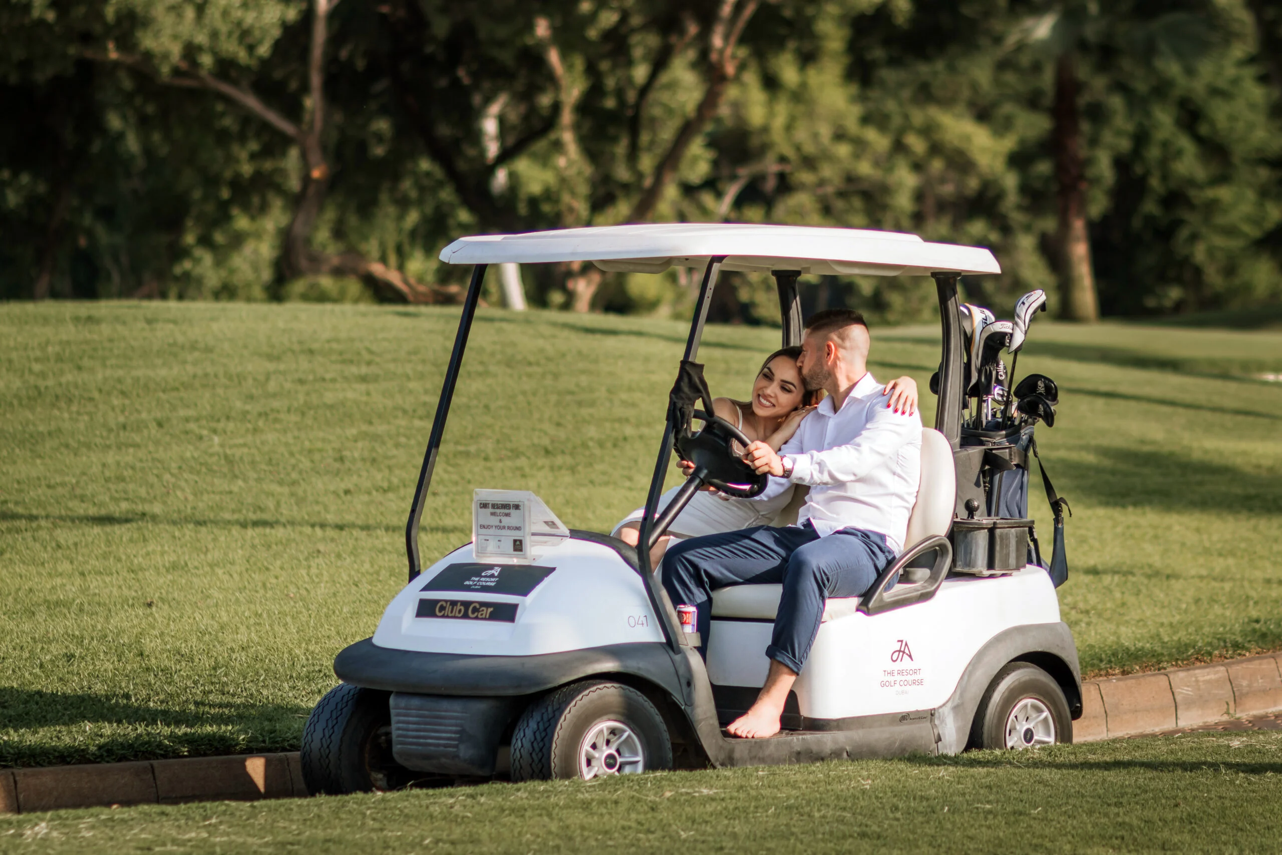 Couple sitting together in a golf buggy on the course