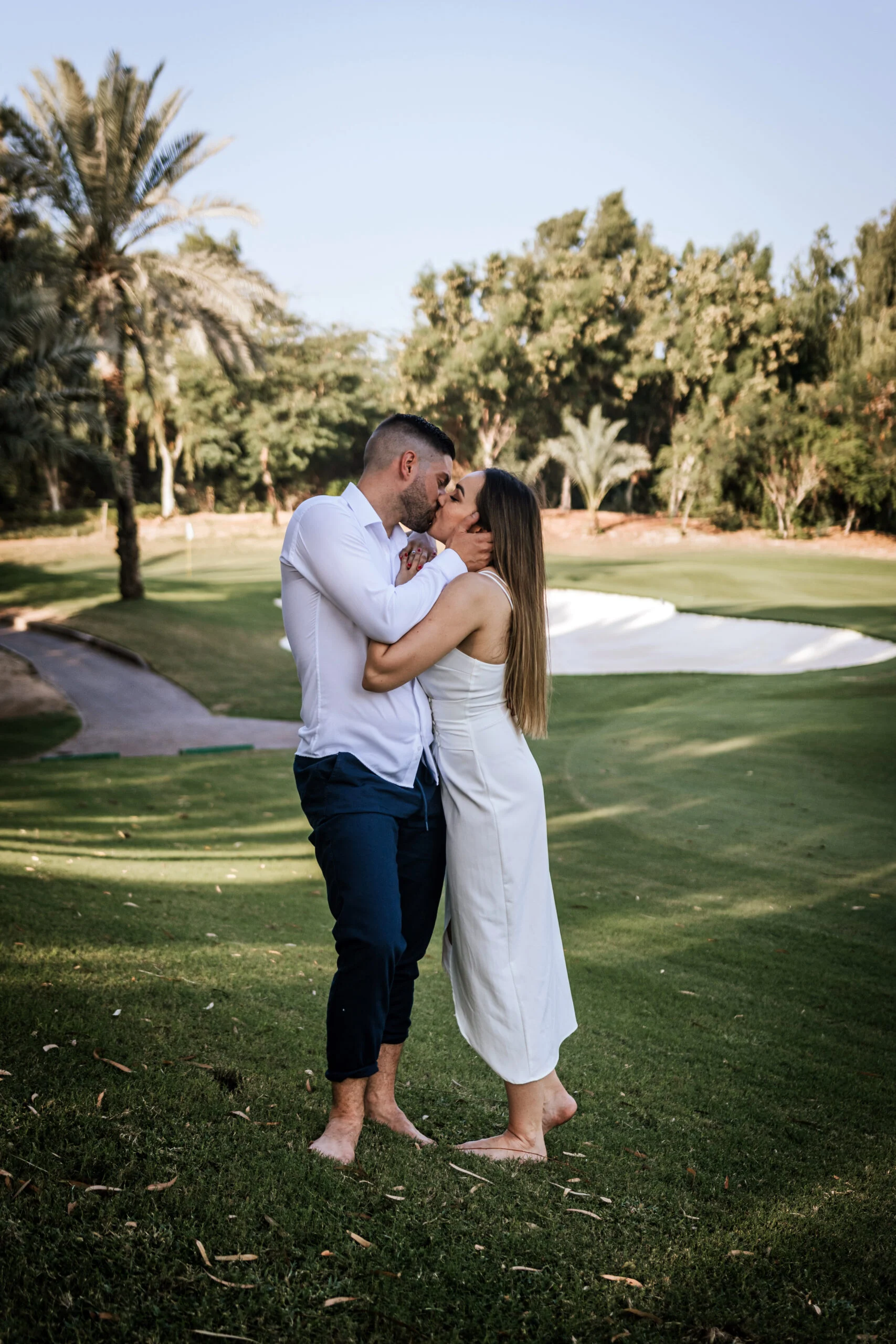 Couple embracing on the fairway in the early light