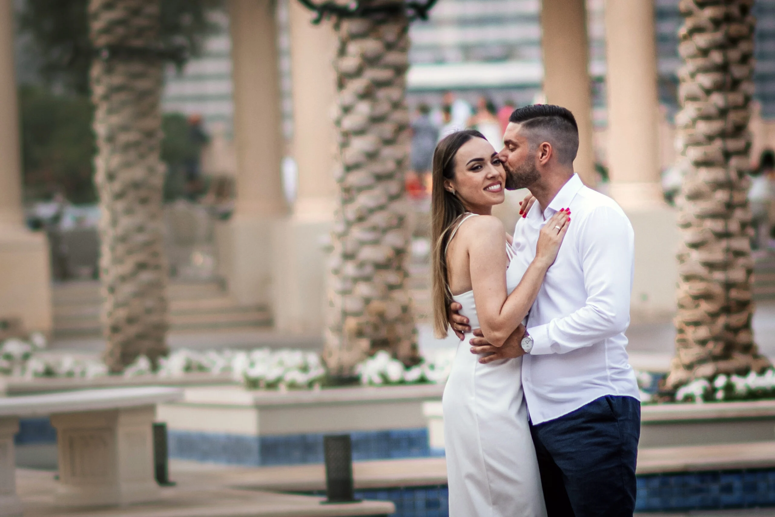 Couple close together in front of a colonnade