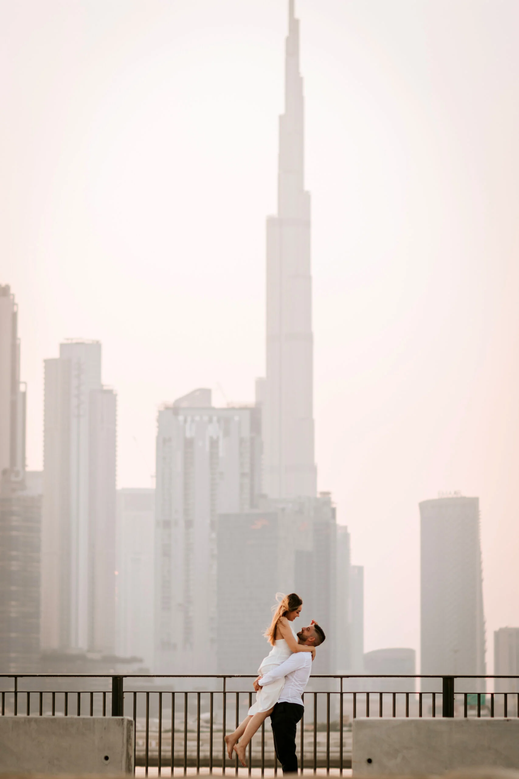 Couple below the Burj Khalifa seen through the haze