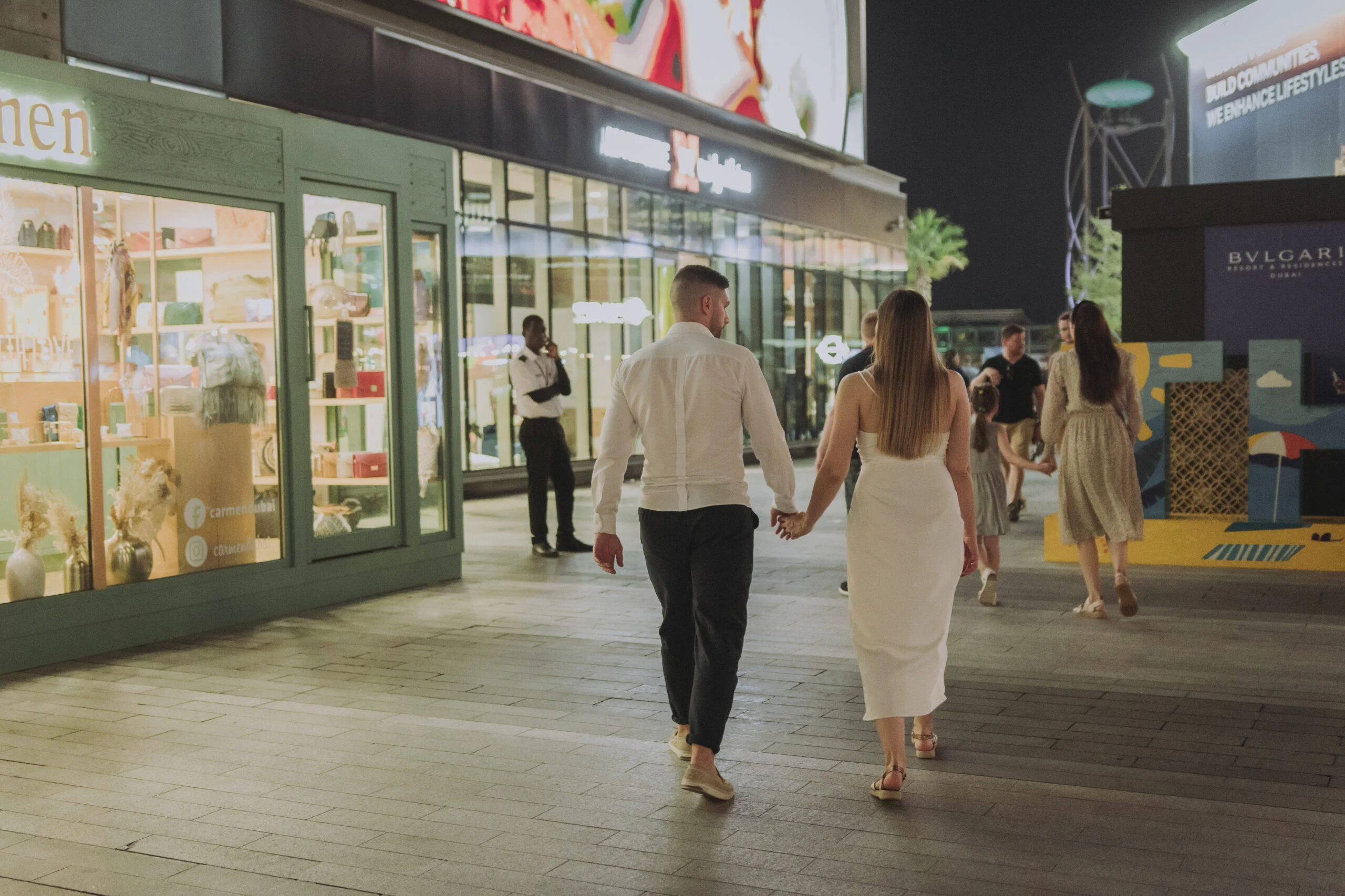 Couple walking away along an illuminated promenade