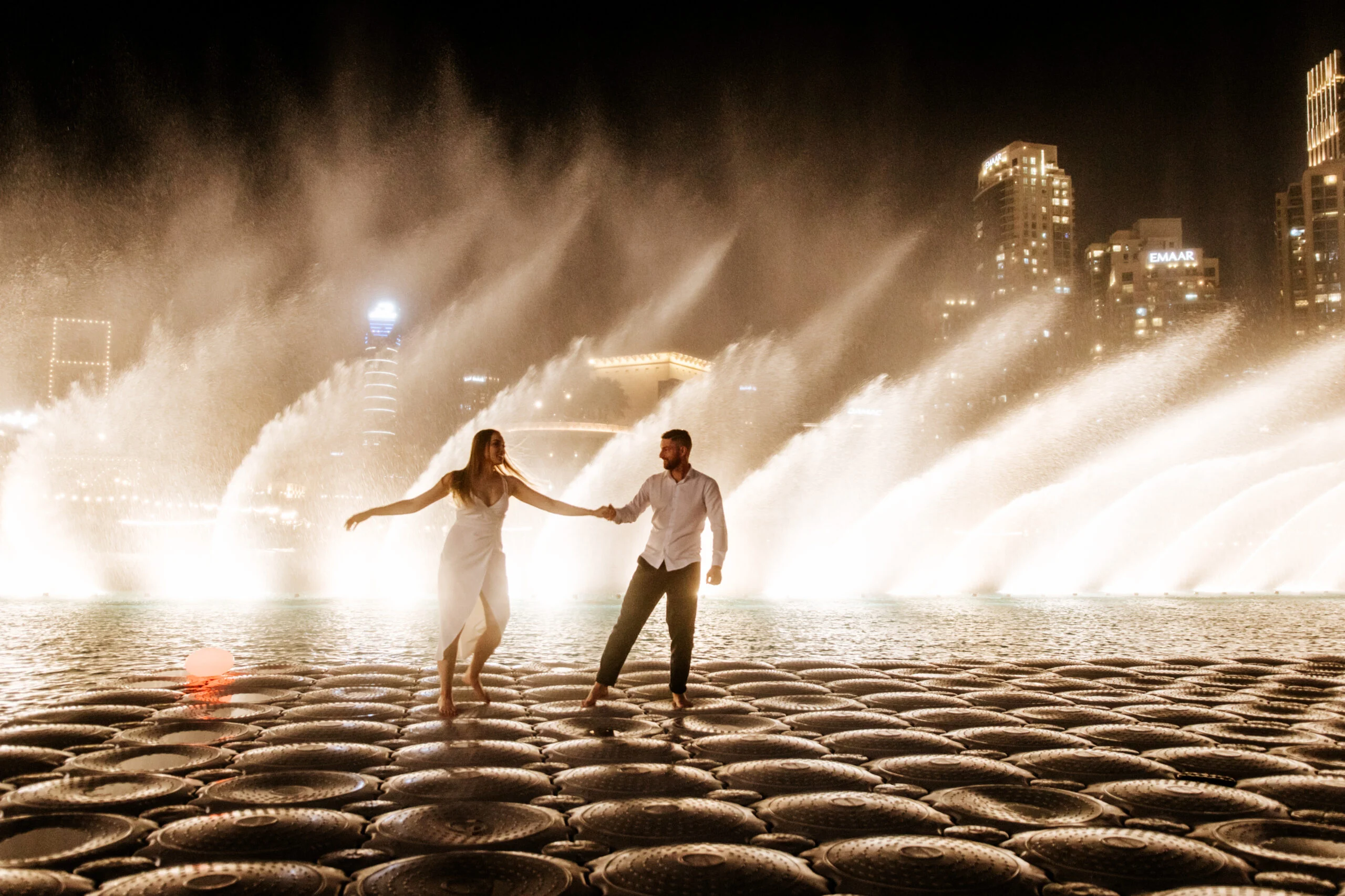 Couple walking together beside the fountain pool