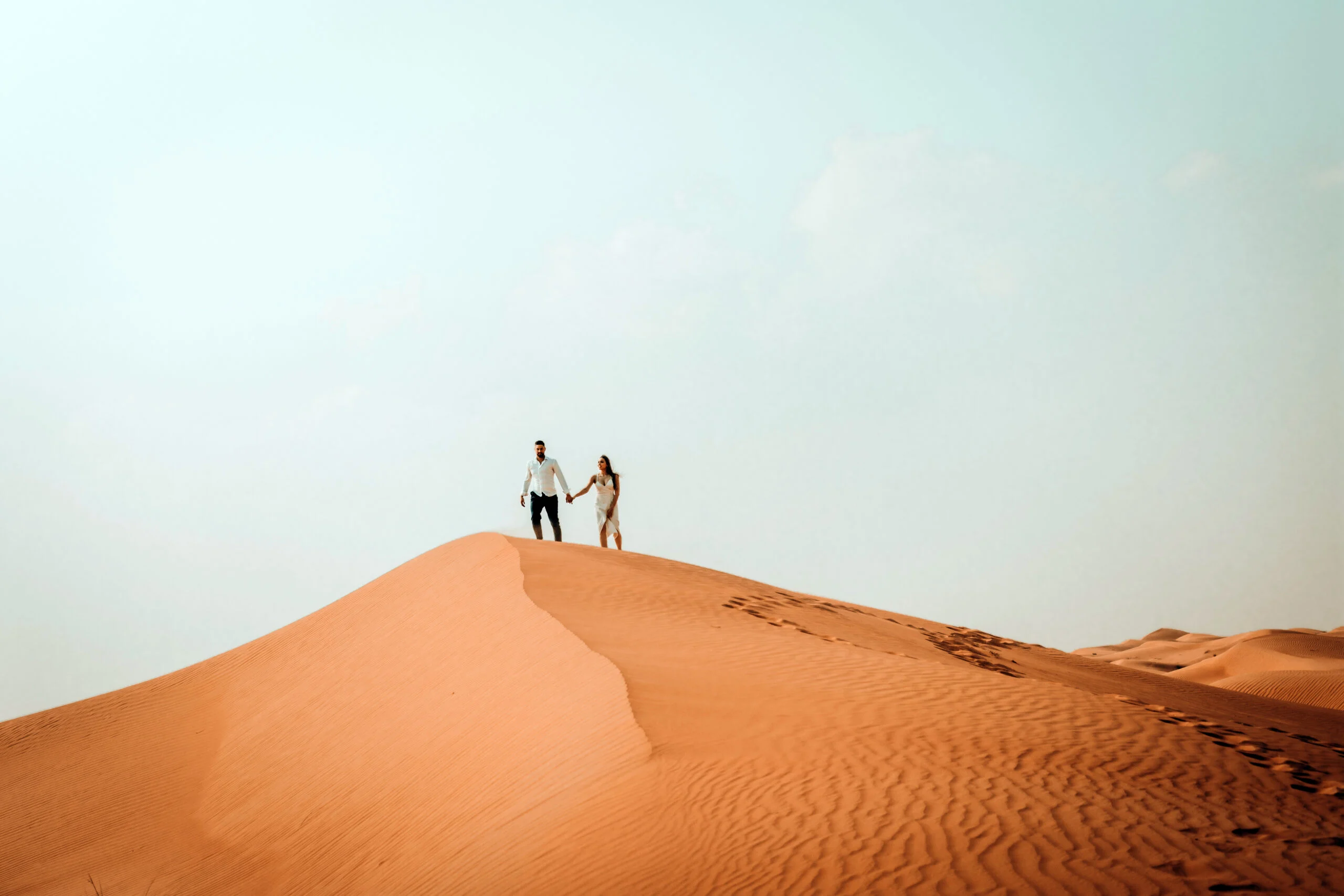 Couple on the dune ridge seen from a distance