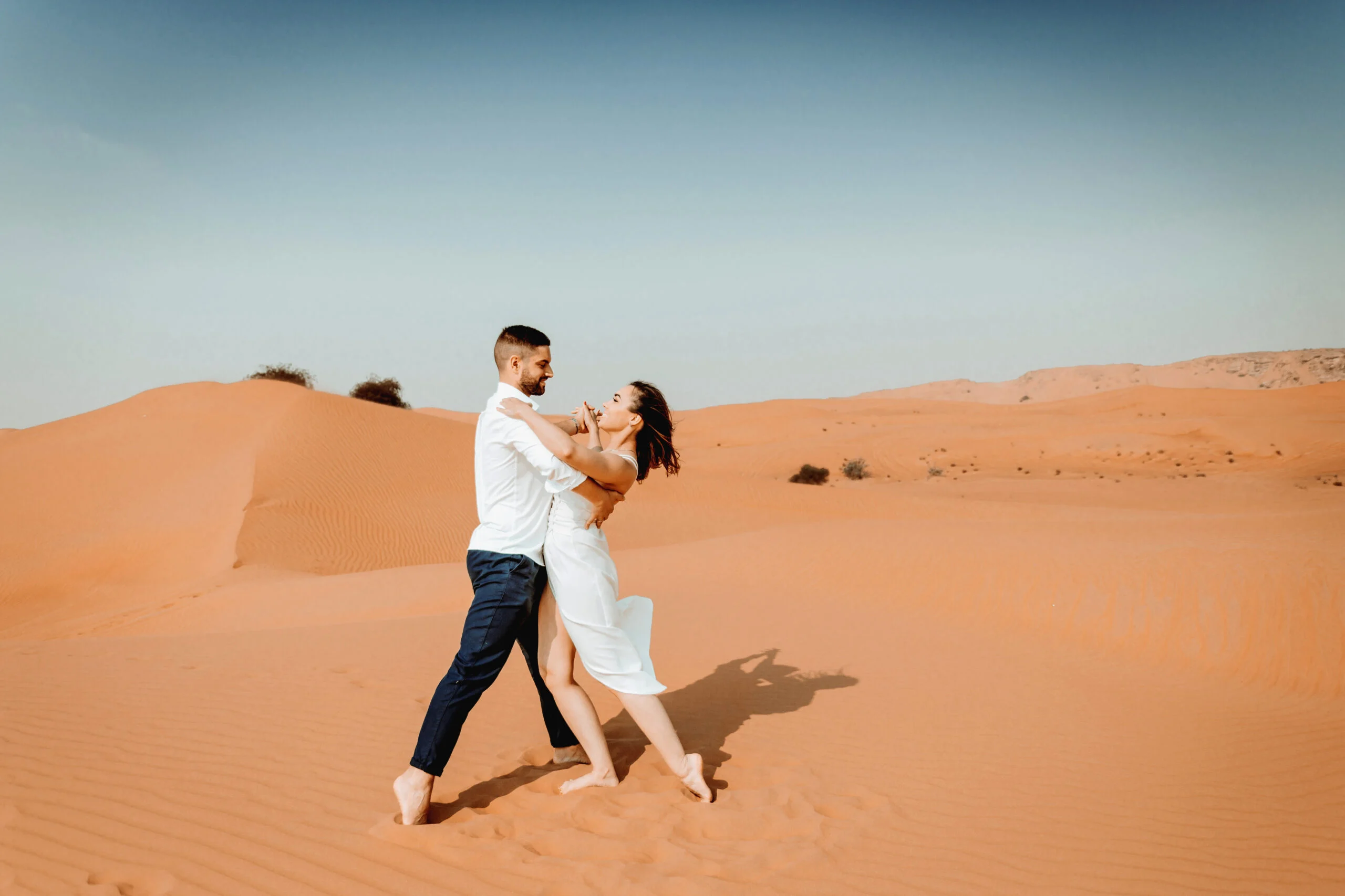 Man lifting the woman on the sand