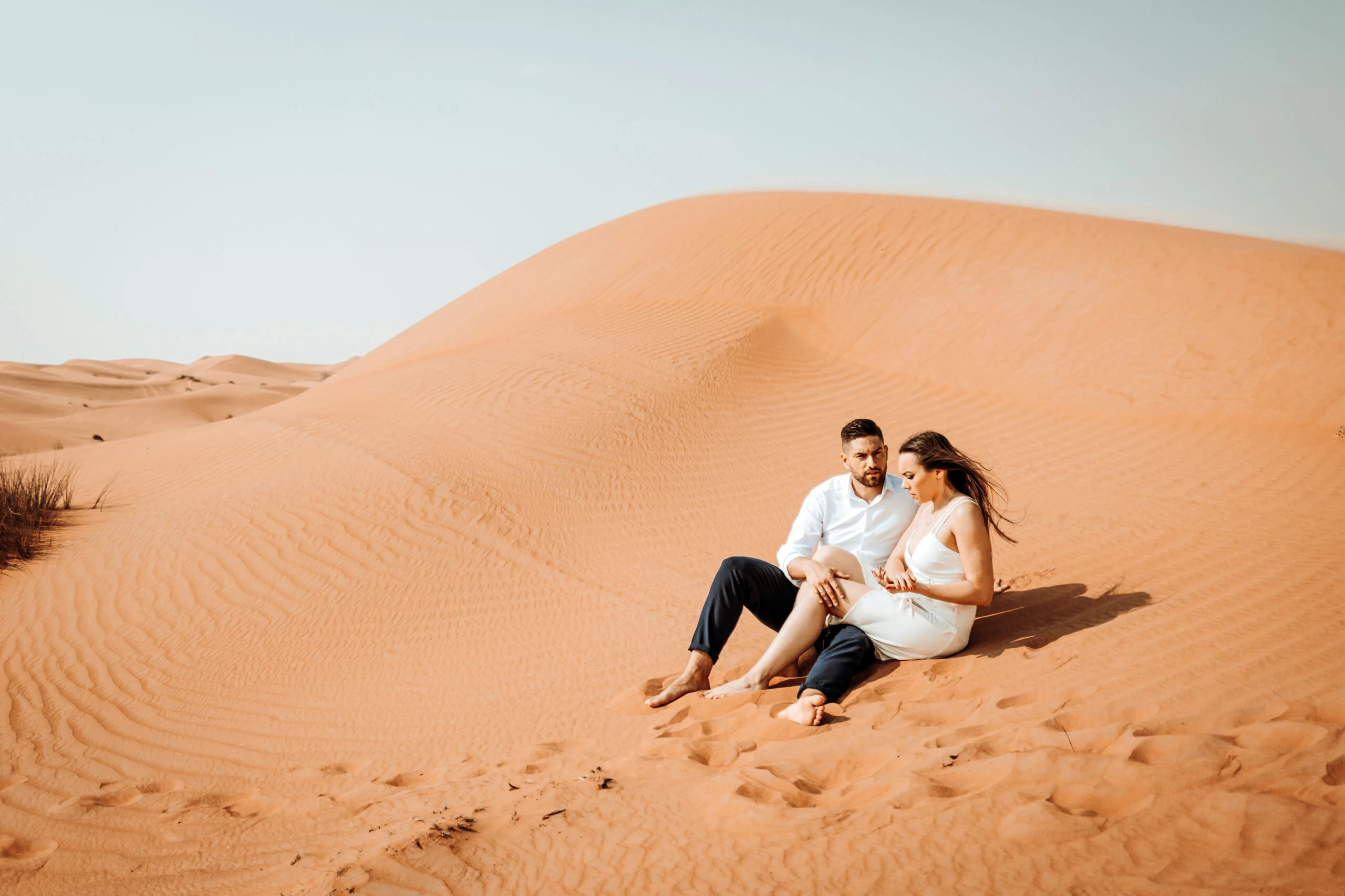 Couple sitting together on a dune