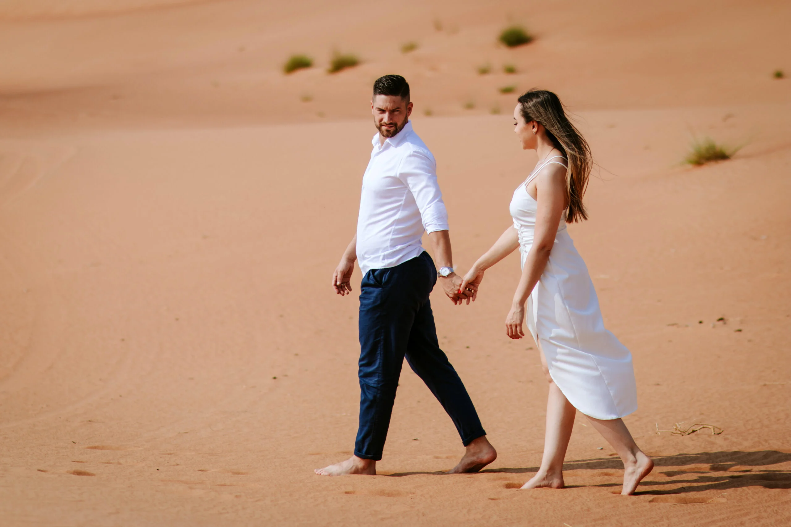 Couple walking apart across the sand