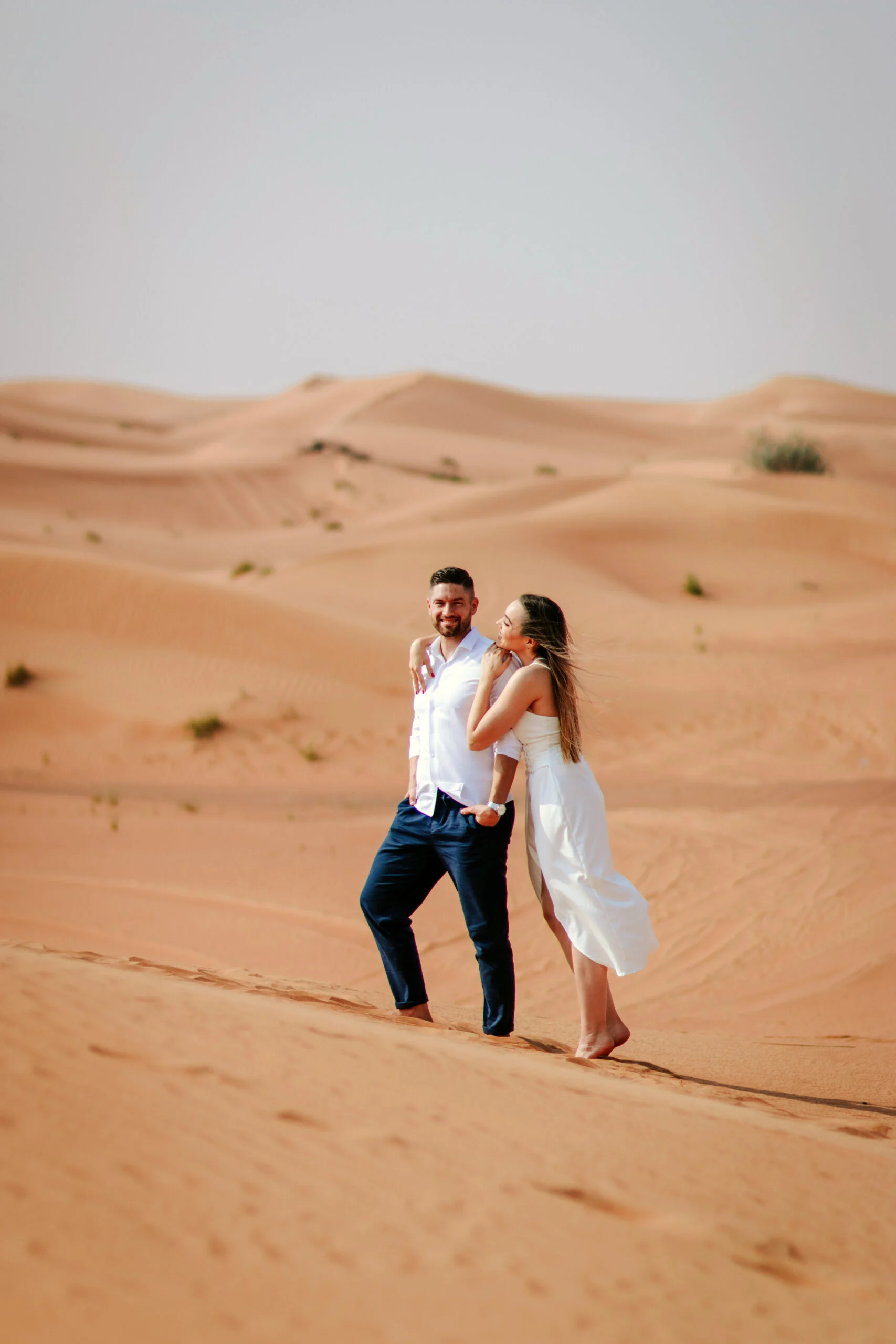 Couple embracing among the dunes in soft light