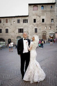 Bride and groom on a medieval town square in Tuscany