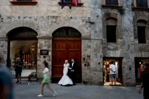 Bride walking through a stone archway in the town centre