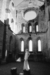 Black and white photograph of the bride alone in the roofless nave