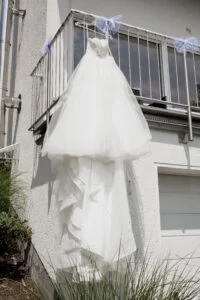 The wedding dress hanging from a balcony railing
