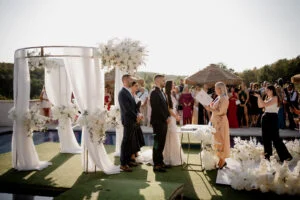 Bride and groom at the altar during the ceremony, surrounded by guests