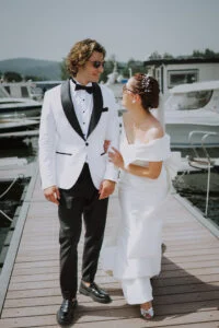 Couple walking a wooden pontoon between moored boats