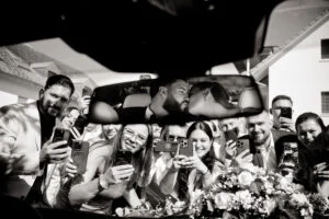 Black and white photograph of guests raising their glasses at the table