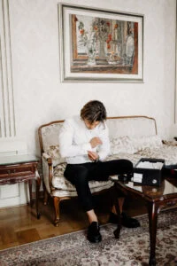 Groom sitting alone on a hotel sofa, getting ready before the ceremony
