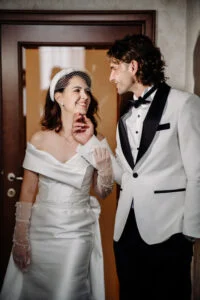 Bride laughing with the groom in a hotel corridor