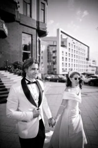 Black and white photograph of the couple crossing a Belgrade street hand in hand