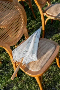 A parasol left on a cane chair on the grass