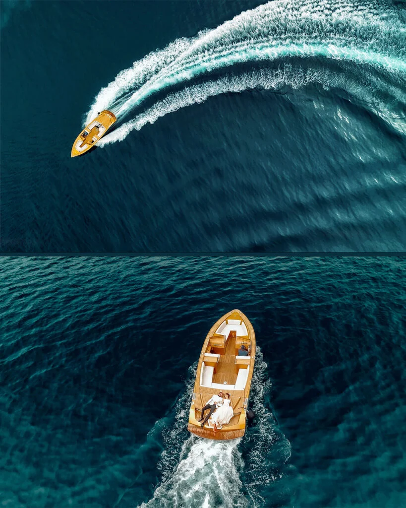 Aerial view of a wooden boat crossing the bay, leaving a long wake