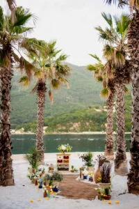 Wedding table set between palm trees above the Bay of Kotor