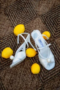 The bride's shoes and fresh lemons arranged on a patterned floor
