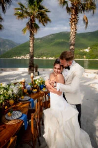 Bride and groom embracing beside the laid table