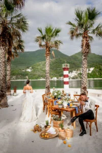 The laid table on the terrace, the couple seated at either end