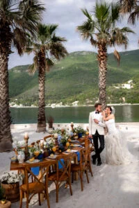 Bride and groom embracing at the end of the table among the palms