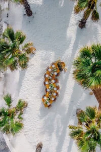 Aerial view of the wedding table laid out on a white terrace among palms