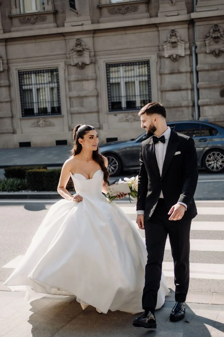 Bride and groom on the pavement in front of a stone building in Belgrade