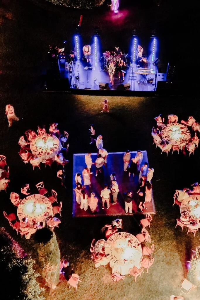 Aerial view of the stage and round dinner tables lit at night
