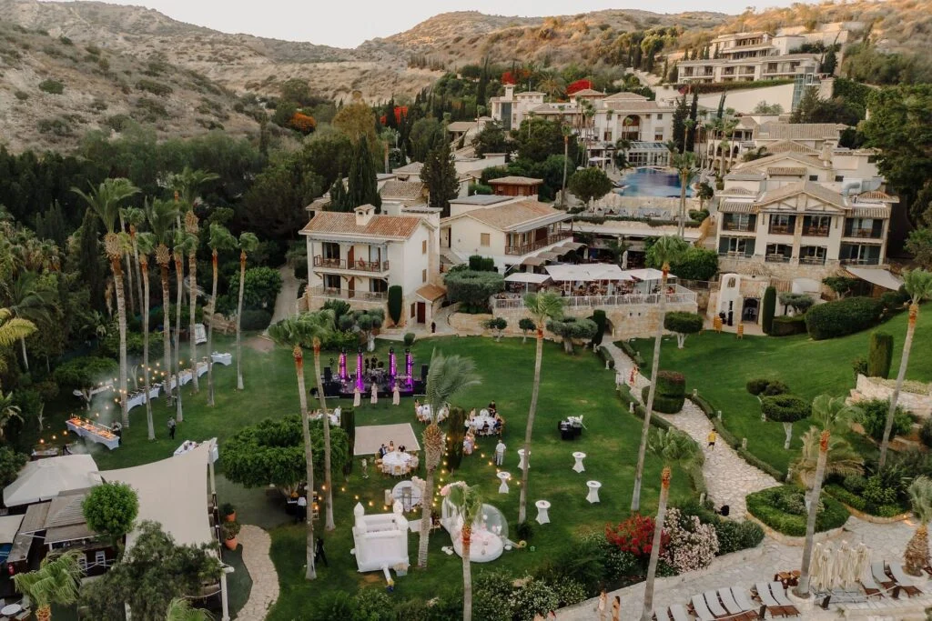 Stone villas and gardens of a hillside resort in Cyprus, the sea beyond